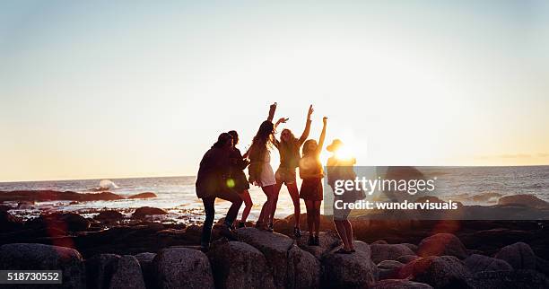 hipster fun loving friends dancing at beach on sunset - party beach stockfoto's en -beelden