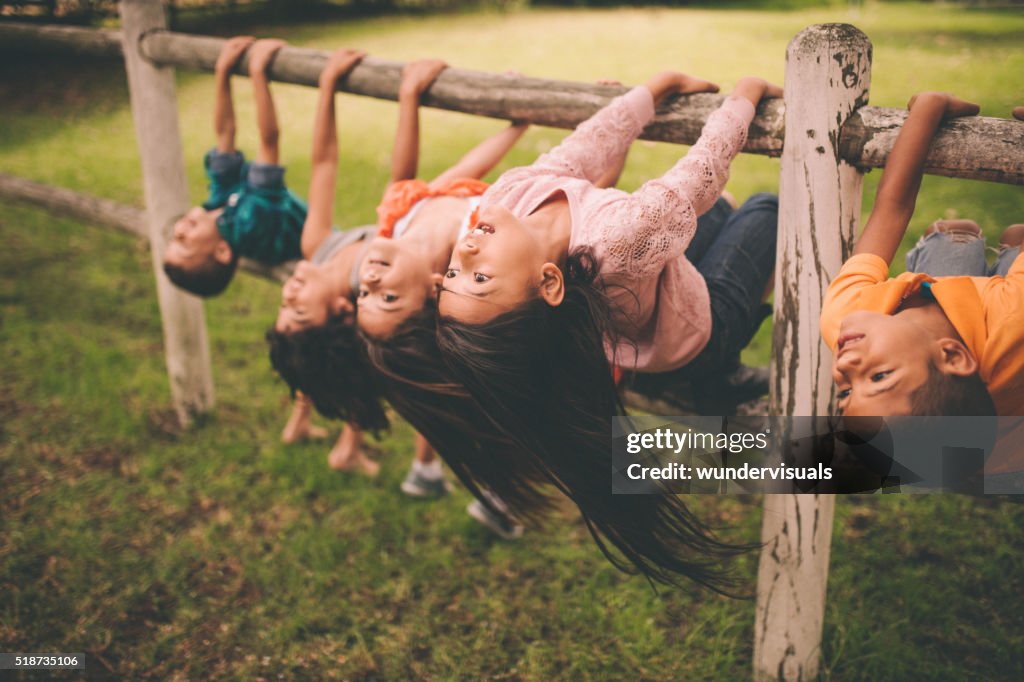 Diverse gemischte ethnische Kinder auf eine Gruppe von Zaun in Park