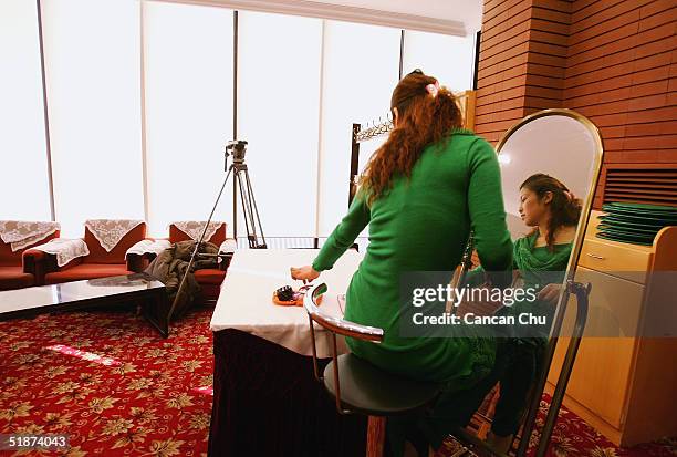 Lu Xiaoyu, a 23 year-old contestant, fixes her make-up after a training session during China's first ever Miss Plastic Surgery contest on December...