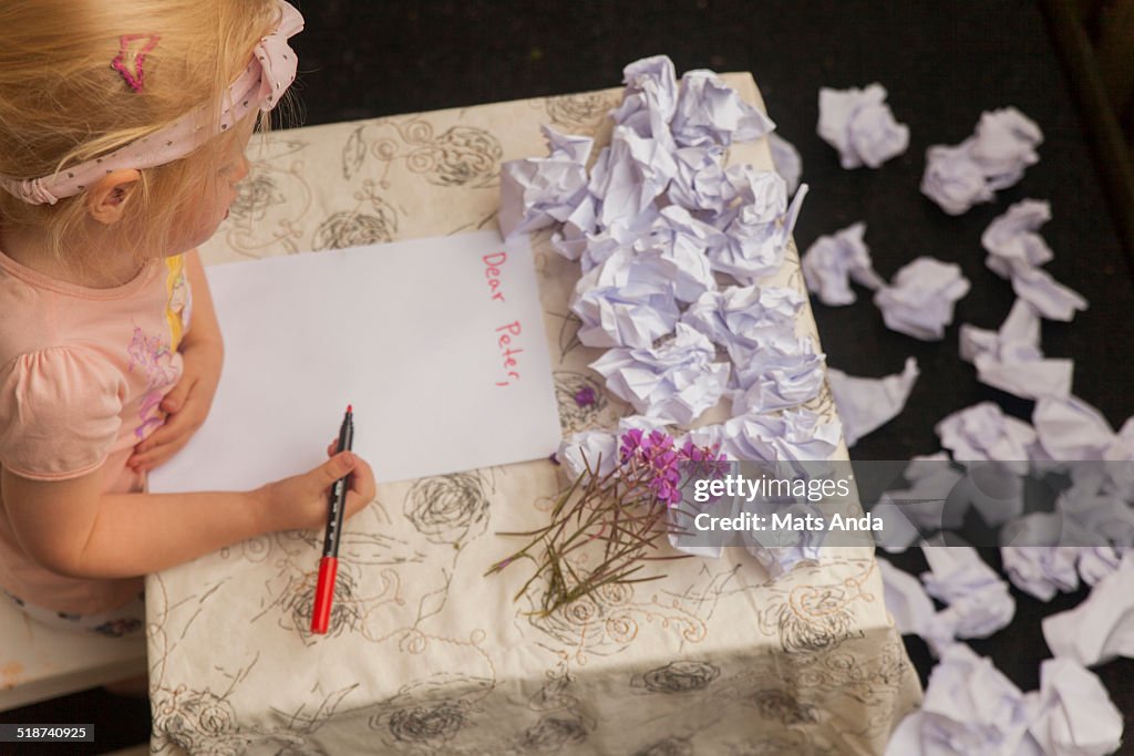 Girl at desk writing "Dear Peter"