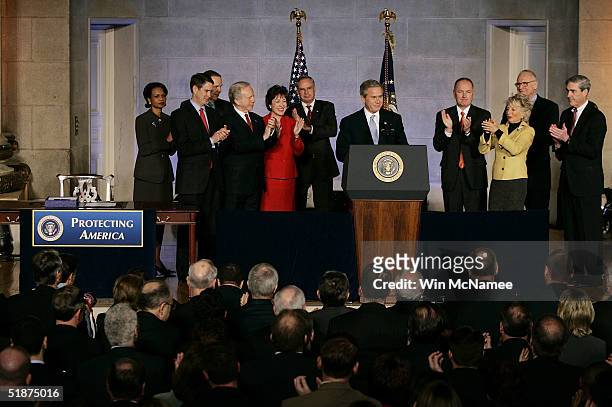 President George W. Bush is applauded before signing the intelligence reform bill by National Security Advisor Condoleezza Rice, Sen. Bill Frist ,...