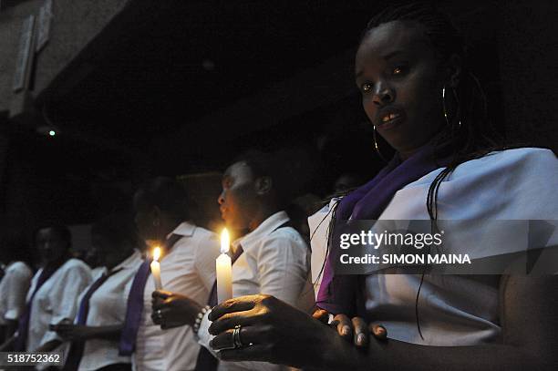 Former students of the Garissa Univesity College hold candle on the memorial for the victims of last year's terrorist attack that killed 148 people...