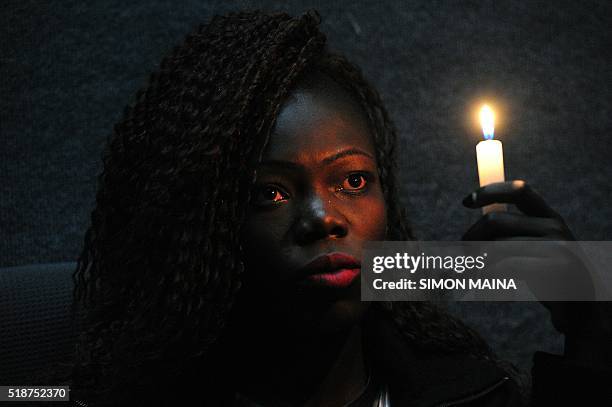 Christine Ochieng holds a candle on the memorial for the victims of last year's terrorist attack that killed 148 people at the campus of Garissa...