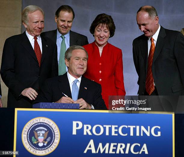 President George W. Bush signs the intelligence reform bill into law December 17, 2004 in Washington, DC. Joining the president on stage are Sen Joe...