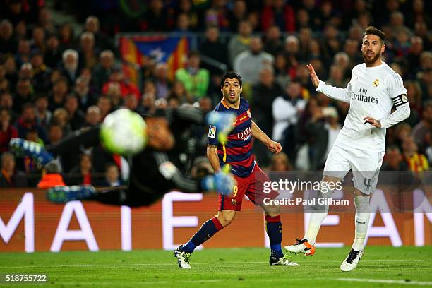 Luis Suarez of FC Barcelona watches his shot fly past Keylor Navas of Real Madrid CF and wide of the post as Sergio Ramos of Real Madrid CF looks on...