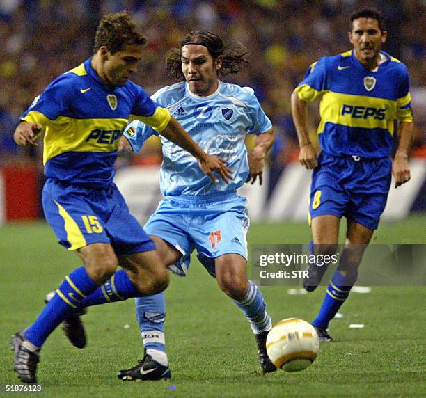 Jose Calvo of Boca Juniors of Argentina and Ruben Tufino of Bolivar de La Paz, Bolivia, vie for the ball while Diego Cagna looks on during the Copa...