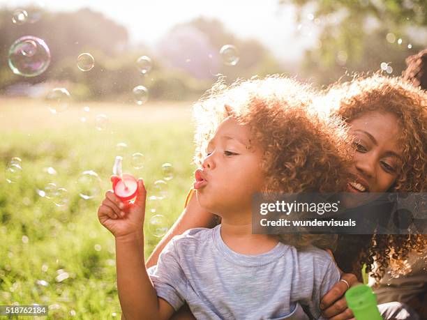 trasognata morbido intimo momento tra una madre e suo ragazzo - bubble wand foto e immagini stock