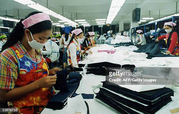Employees of a garment factory check the quality of stitched garments before packing in the outskirts of the Cambodian capital city Phnom Penh, 18...