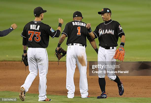 The Miami Marlins' Austin Nola , Robert Andino , and Ichiro Suzuki celebrate after a 2-1 win against the New York Yankees in a spring training...