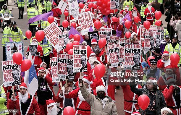 Hundreds of carol singing Father Christmases from campaign group "Fathers 4 Justice" , attend a march on December 18, 2004 in London, England. The...