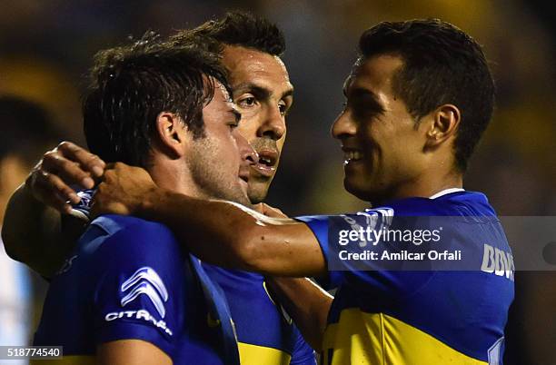 Nicolas Lodeiro of Boca Juniors celebrates with teammate Federico Carrizo and Carlos Tevez after scoring the third goal his team during a match...