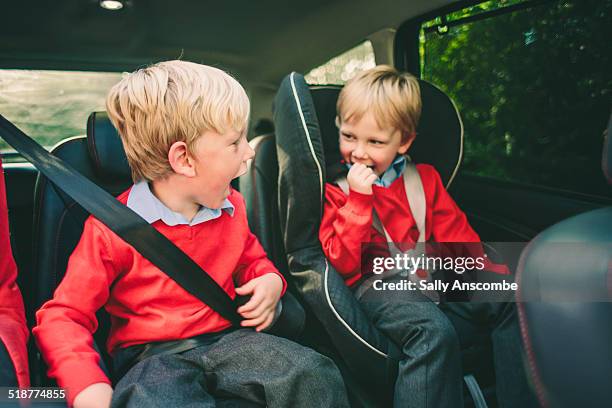 two school children in the car - kid car seat stock pictures, royalty-free photos & images