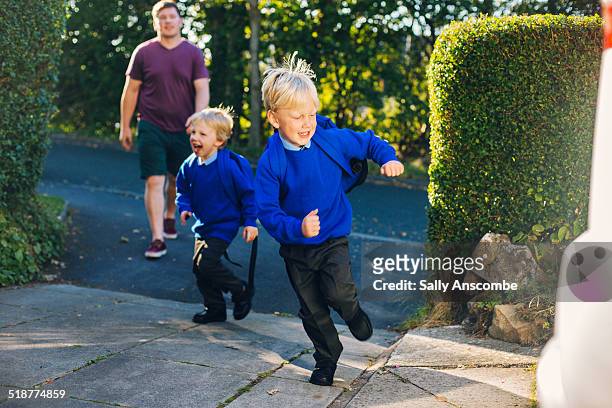 school children running home - schooluniform stockfoto's en -beelden