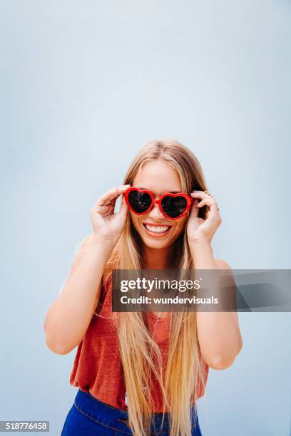 blonde happy teenage girl with heart sunglasses - heart sunglasses stock pictures, royalty-free photos & images