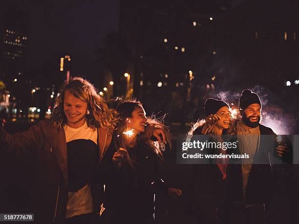 hipster friends having night party with sparklers in the city - evening walk stock pictures, royalty-free photos & images