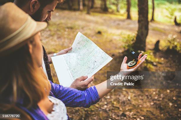 couple of tourists using compass and map - orienteering stock pictures, royalty-free photos & images
