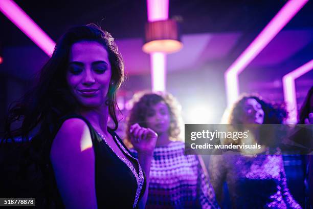 young woman enjoying dancing with friends in a night club - girl swing stockfoto's en -beelden