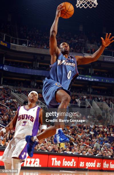 Gilbert Arenas of the Washington Wizards shoots while Quentin Richardson of the Phoenix Suns watches on December 18, 2004 at America West Arena in...