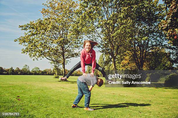 children playing leapfrog - bockspringen stock-fotos und bilder