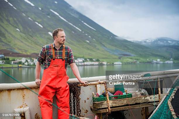 fisherman standing on fishing boat - pêcheur photos et images de collection