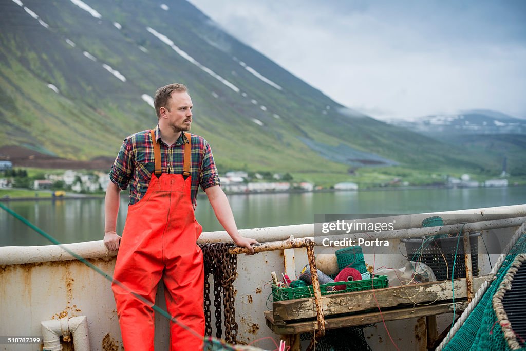 Fisherman standing on fishing boat