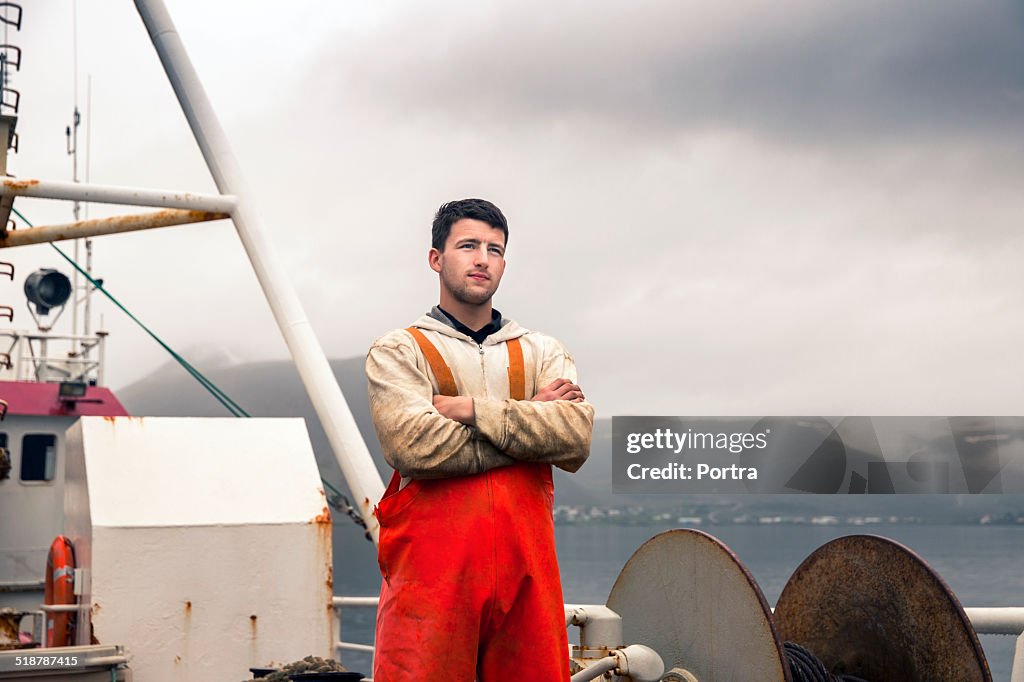 Confident fisherman standing on fishing boat