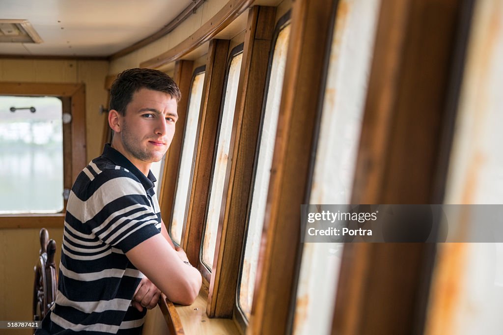 Confident fisherman standing in fishing boat