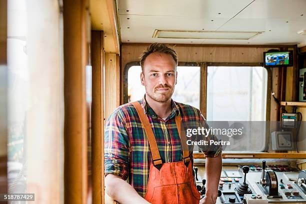 confident fisherman in fishing boat - fisherman foto e immagini stock