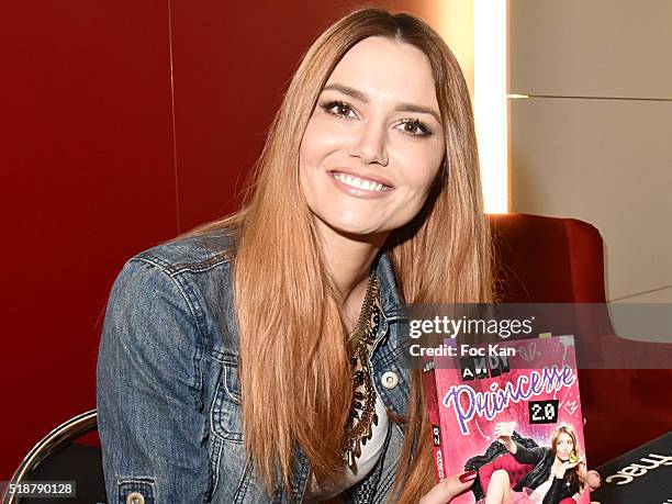 Youtuber Andy Raconte poses with her book during the Youtuber Andy Meets Her Fan At FNAC Bercy in Paris on April 2, 2015 in Paris; France.