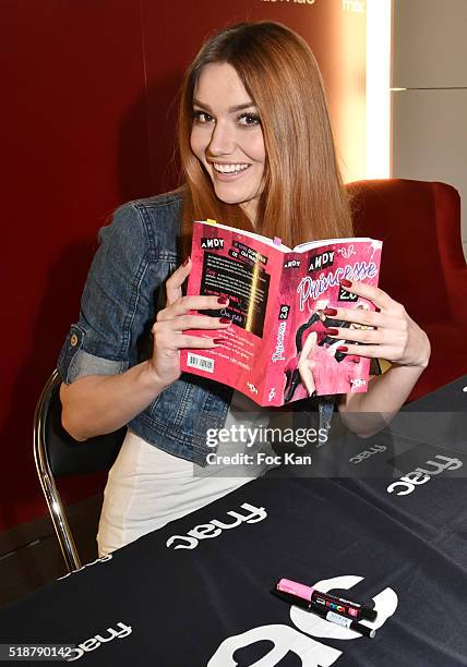 Youtuber Andy Raconte poses with her book during the Youtuber Andy Meets Her Fan At FNAC Bercy in Paris on April 2, 2015 in Paris; France.