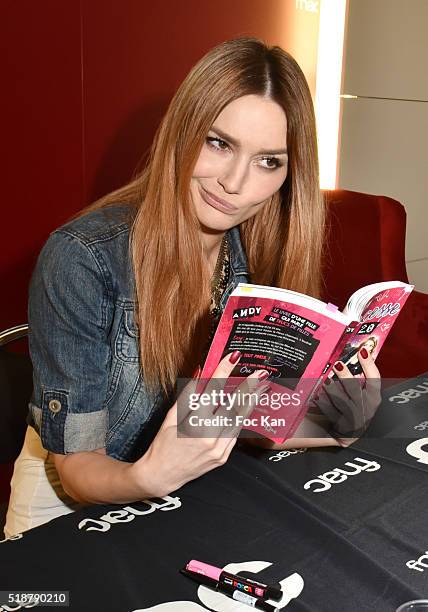 Youtuber Andy Raconte poses with her book during the Youtuber Andy Meets Her Fan At FNAC Bercy in Paris on April 2, 2015 in Paris; France.