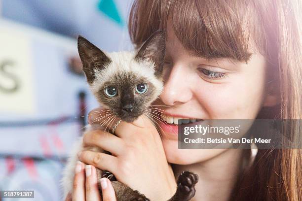 close up of teenager holding kitten. - kittens stock pictures, royalty-free photos & images