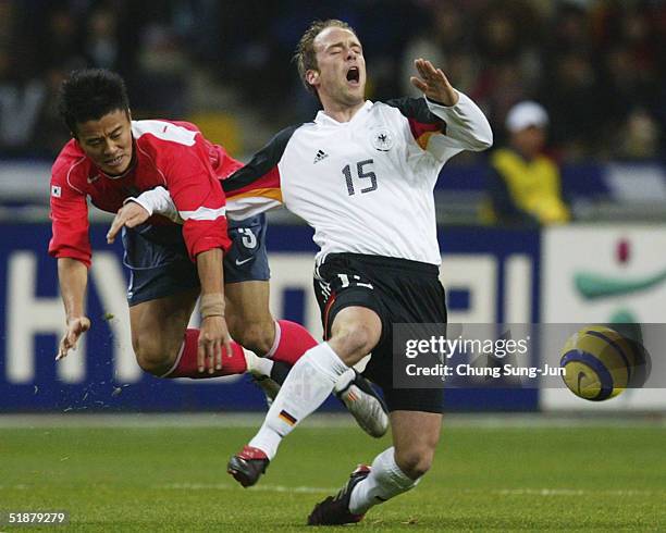 Fabian Ernst of Germany is brought down by Park Jae-Hong of South Korea during the International Friendly match at the Asiad Main Stadium on December...