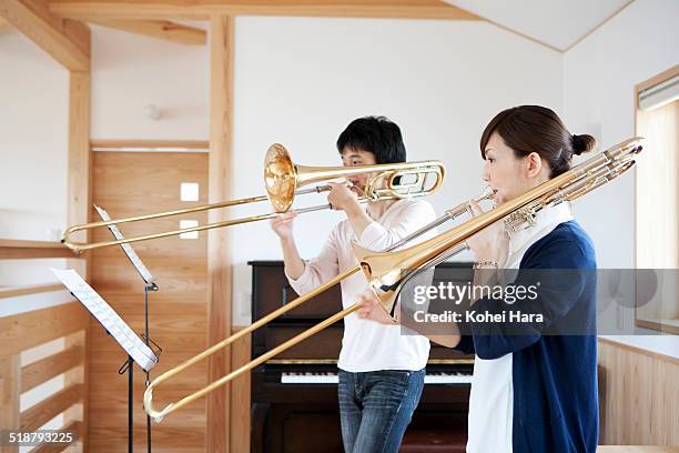 a musical couple playing the musical instruments - trombone stock pictures, royalty-free photos & images