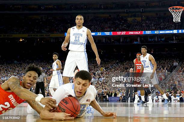 Brice Johnson of the North Carolina Tar Heels looks on as Justin Jackson dives for a loose ball against Malachi Richardson of the Syracuse Orange in...