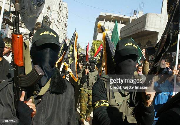 Masked militants from Islamic Jihad attend the funeral of the 11 Palestinians killed in an Israeli raid December 19, 2004 in Khan Younis refugee...