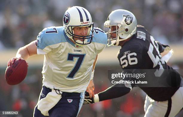 Quarterback Billy Volek of the Tennessee Titans evades the sack attempt from linebacker Travian Smith of the Raiders on December 19, 2004 at Network...