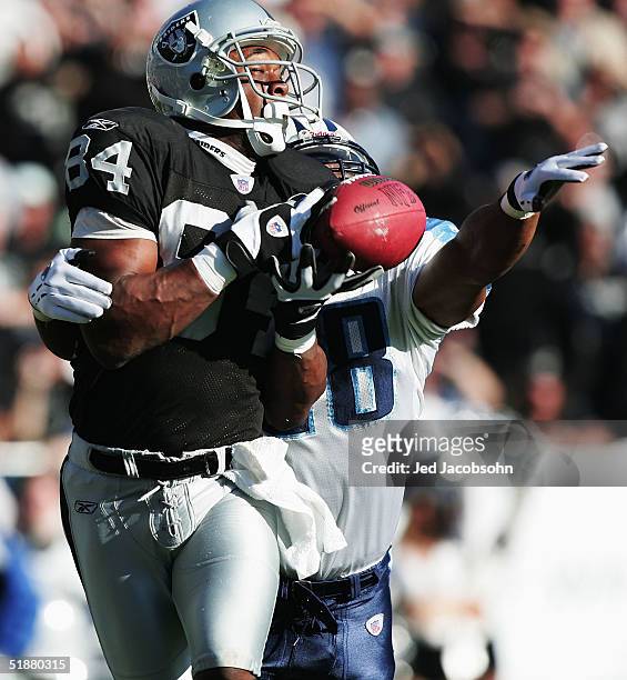 Wide receiver Jerry Porter of the Oakland Raiders is unable to catch the ball against pressure from safety Lamont Thompson of the Tennessee Titans at...