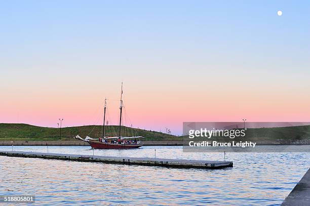 retreating to harbor at dusk - burnham park harbor stock pictures, royalty-free photos & images