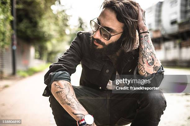 hipster sitting pensive with tattoo - handsome rugged man stock pictures, royalty-free photos & images