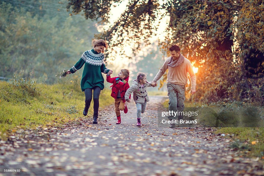 Jovem alegre família se divertindo enquanto corre no parque.