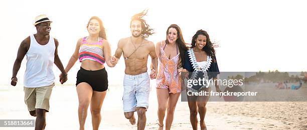 group of friends running on the beach - fat man on beach stockfoto's en -beelden