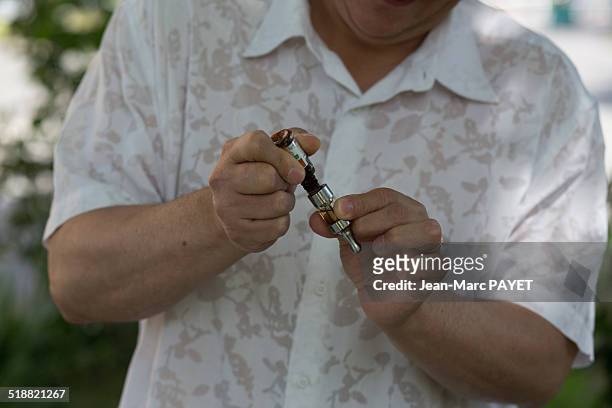man with casual look filling an e-cigarette tank - jean marc payet photos et images de collection