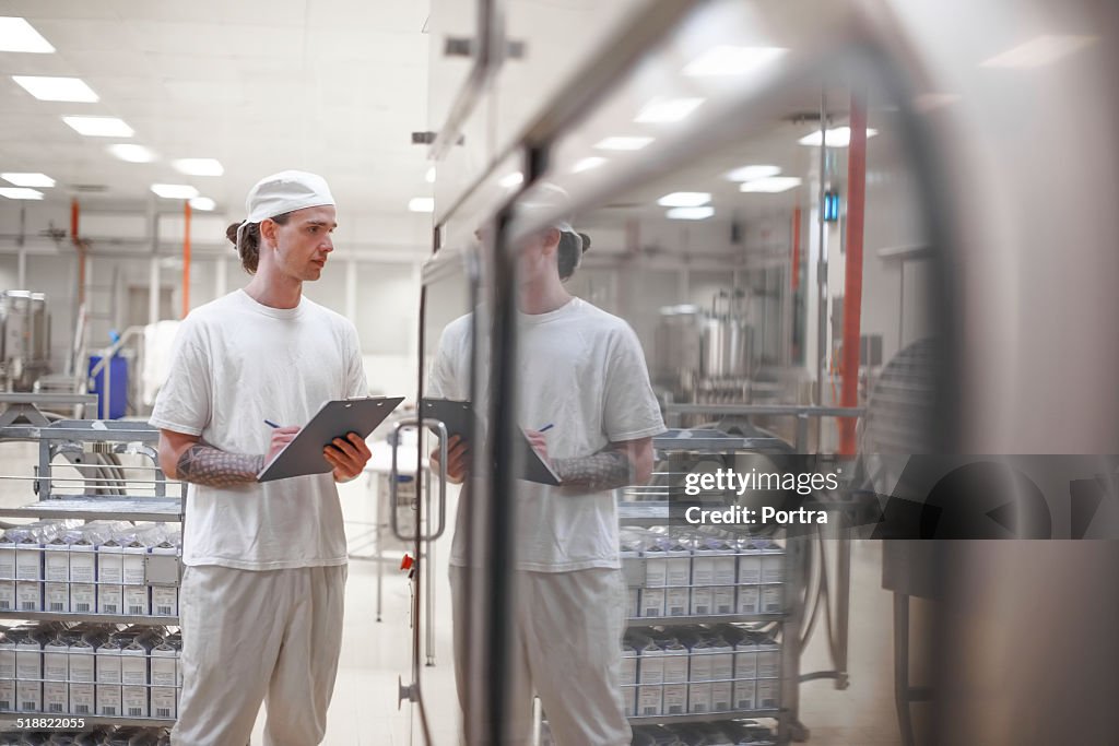 Worker examining products at milk industry