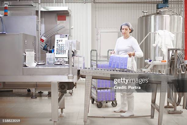 worker carrying milk cartons - milk carton stock pictures, royalty-free photos & images