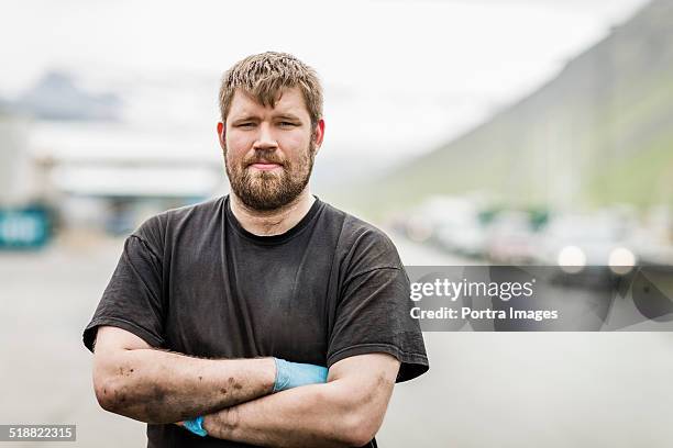 mechanic with arms crossed standing outside garage - blue collar portrait imagens e fotografias de stock