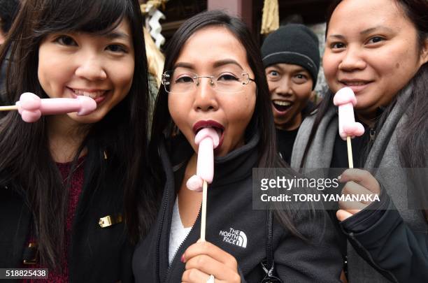 Women hold candy in the shape of phalluses at the Wakamiya Hachimangu Shrine during the Kanamara Festival in Kawasaki, a suburb of Tokyo on April 3,...