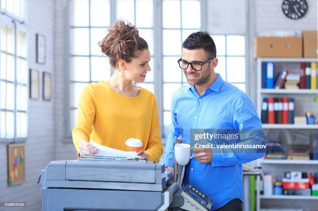 Coworkers working and drinking coffee together at the office