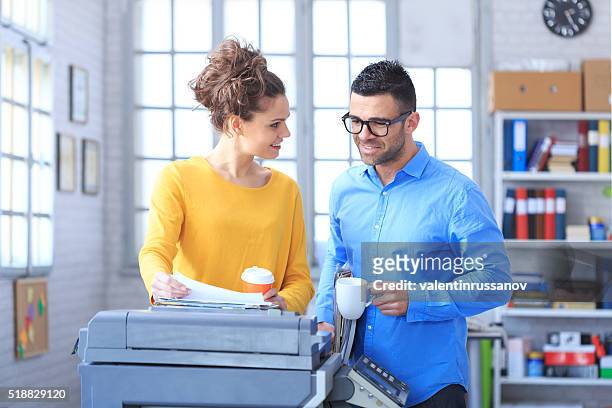 coworkers working and drinking coffee together at the office - copier stock pictures, royalty-free photos & images