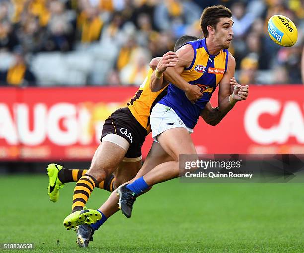 Elliot Yeo of the Eagles handballs whilst being tackled by Shaun Burgoyne of the Hawks during the round two AFL match between the Hawthorn Hawks and...